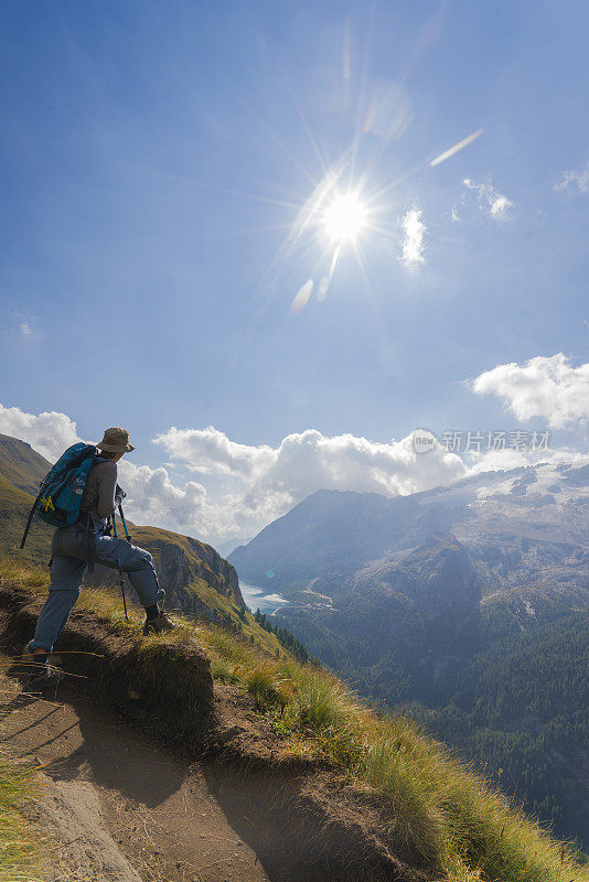 意大利北部Dolomites的Viel dal Pan小路上，一位老妇人正在欣赏美丽的Fedaia湖和Marmolada湖。